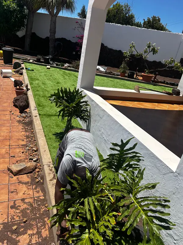 Instalador de Apavi Green colocando césped artificial en una jardinera en Carrizal