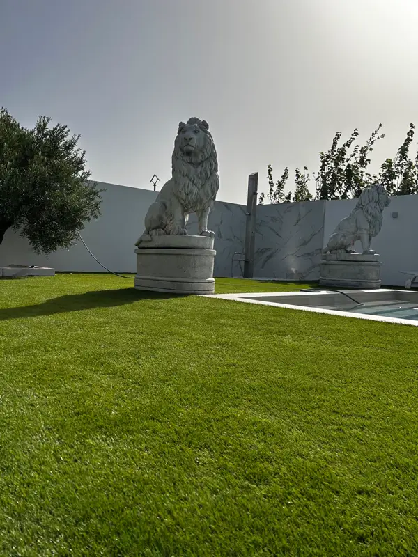 Estatua de león sobre el césped artificial en el jardín de Carrizal