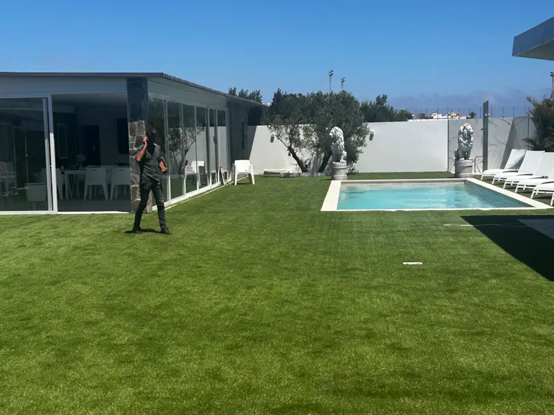 Últimos remates del césped artificial junto a la piscina y el pabellón en Carrizal