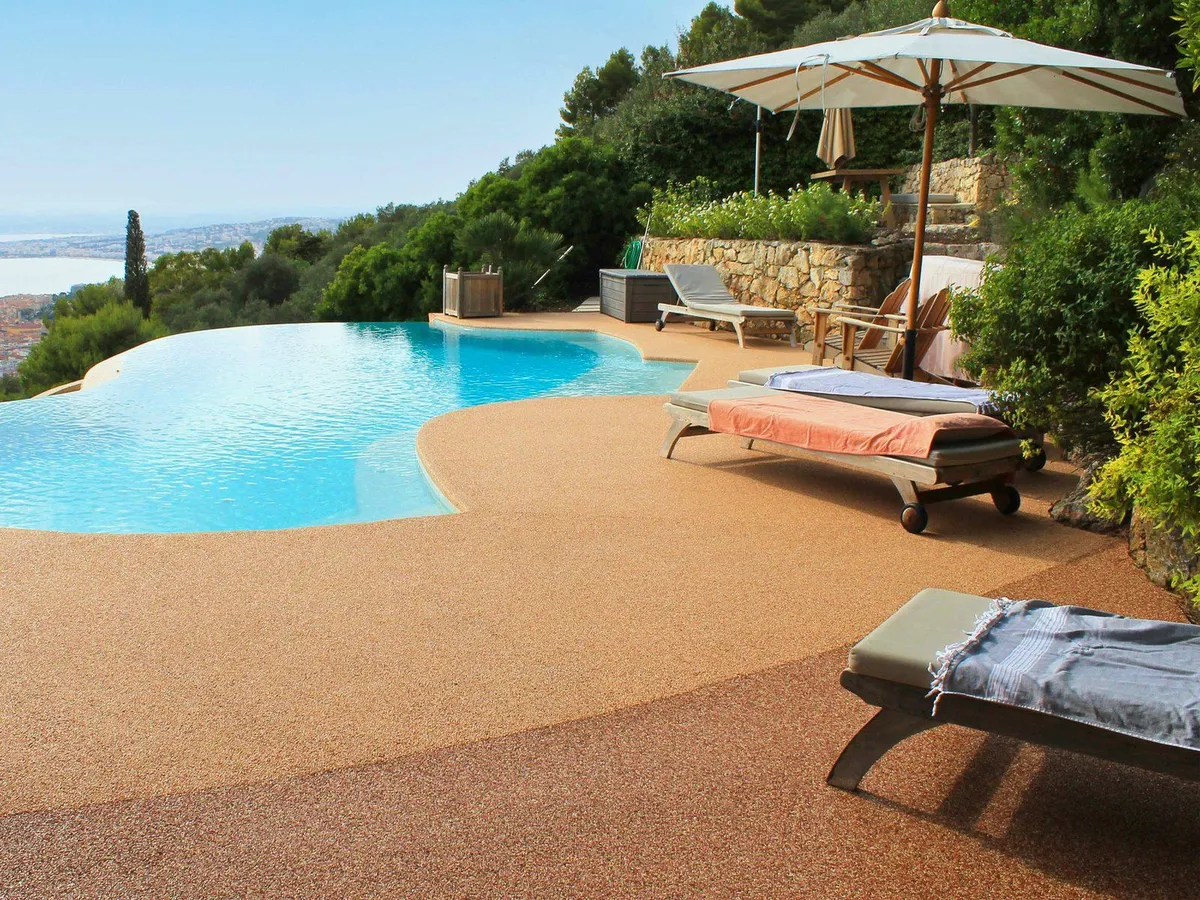 Borde de piscina con suelo drenante antideslizante en tono terracota