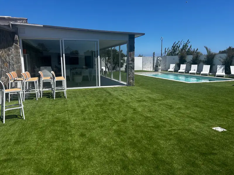 Jardín de césped artificial con piscina y pabellón acristalado en Carrizal, Gran Canaria