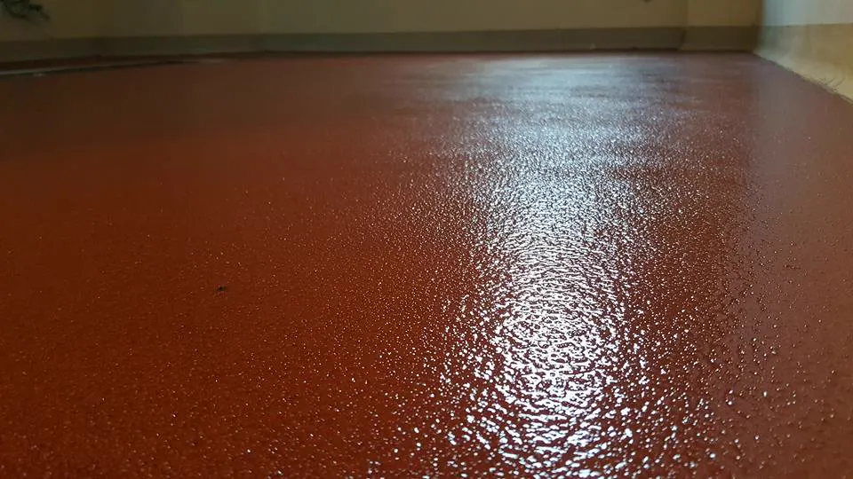 Detalle de suelo de resina epoxi rojo con acabado antideslizante