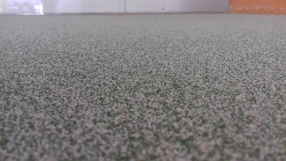 Detalle de suelo de resina epoxi con árido verde en una guardería en Gran Canaria